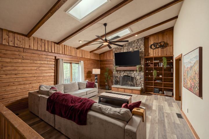 Living room with the hand-whittled log mantel and vaulted beamed ceiling